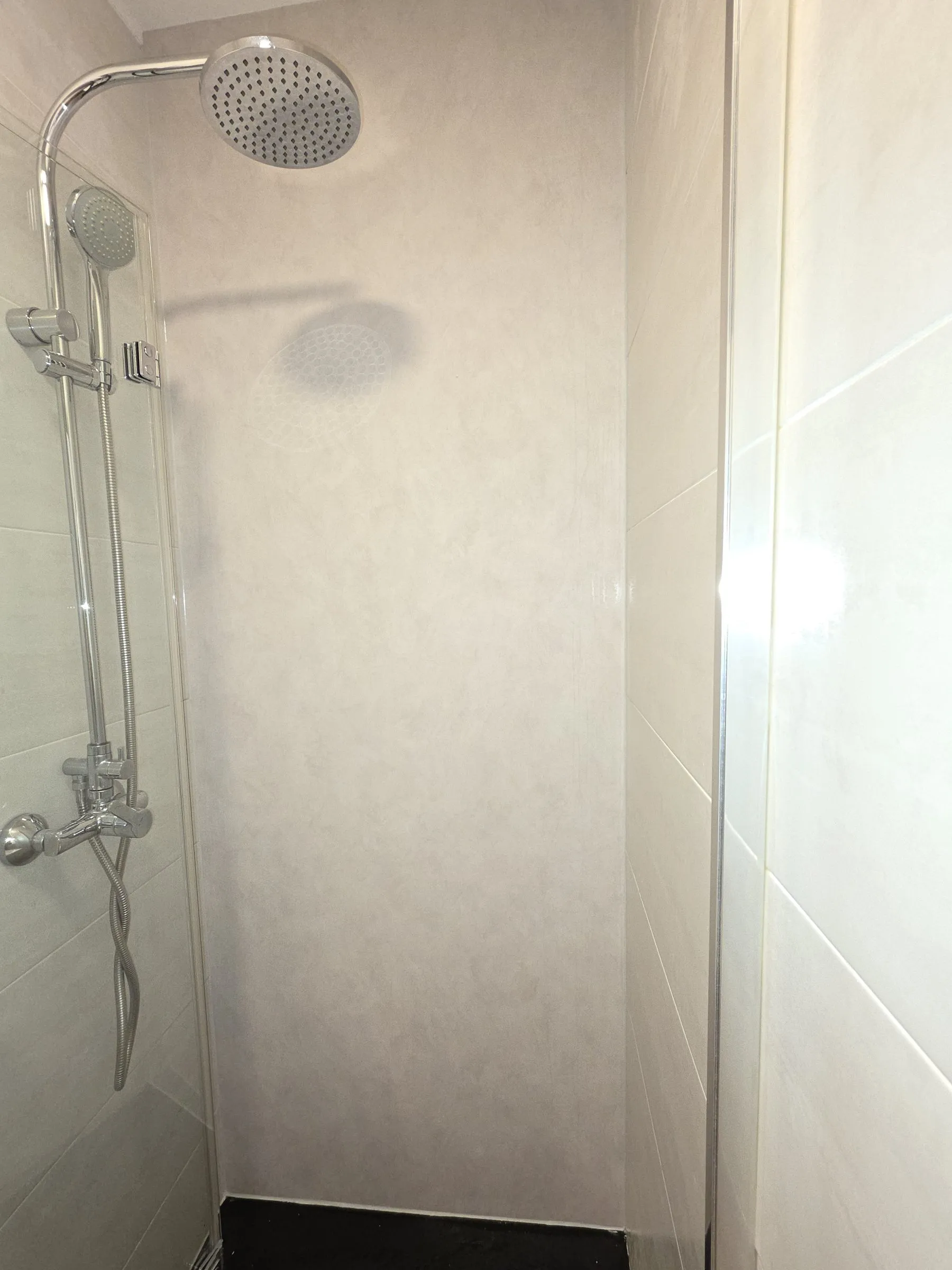 Ducha con la pared revestida en vinilo efecto piedra claro