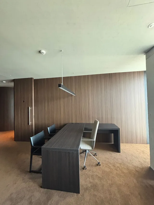 Despacho con mesa oscura y paredes efecto nogal