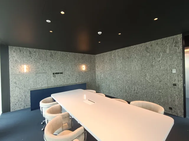 Sala de juntas con papel decorativo y mesa blanca