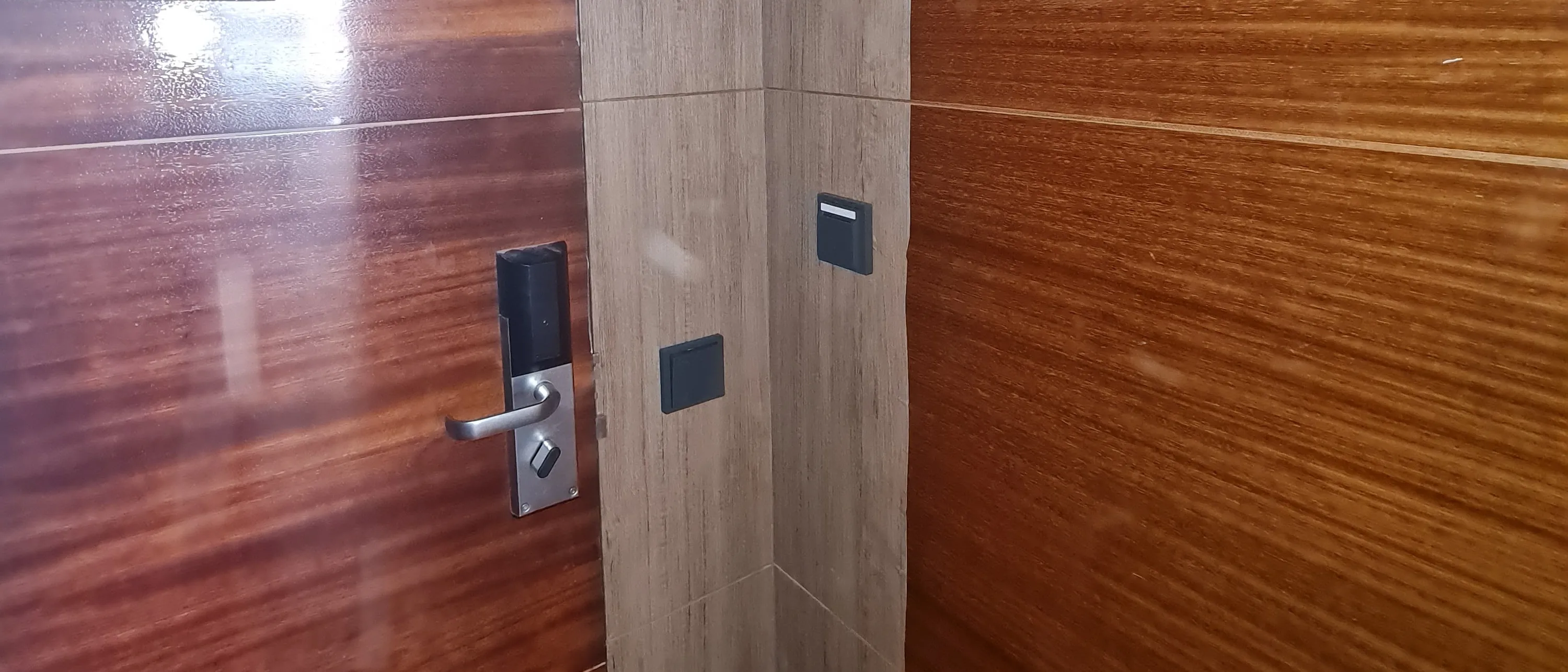 Puerta de habitación y paneles del hall del Hotel NH Marbella revestidos con vinilo SOIF efecto madera