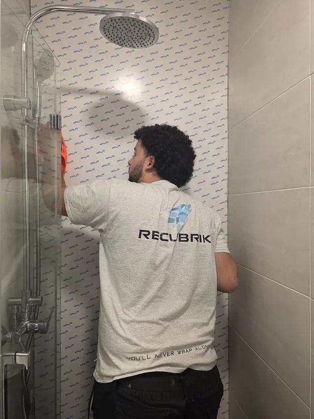 Ajuste del vinilo en la pared de la ducha
