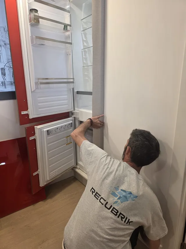 Instalador ajustando el panel del frigorífico integrado