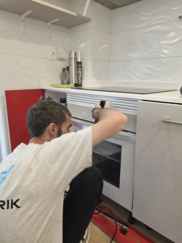 Instalador trabajando en el mueble del horno