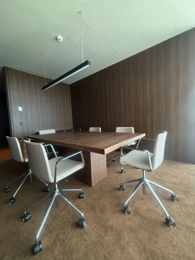 Mesa de reuniones rodeada de paredes efecto madera